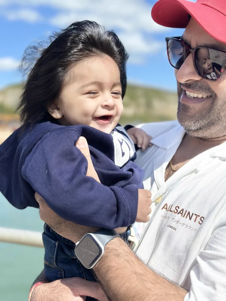 Trayaksh smiling in a parent's arms during an on-location casting session