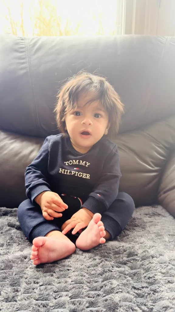 Trayaksh sitting on a sofa in Tommy Hilfiger knitwear during a lifestyle shoot
